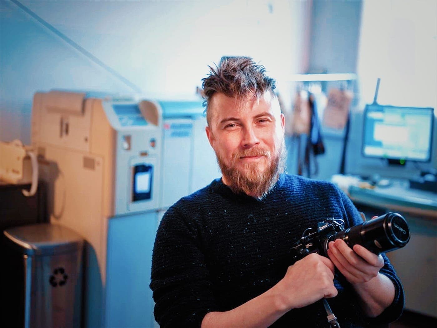 David, founder of Just Shoot Film, holding a film camera in the lab in Norwich