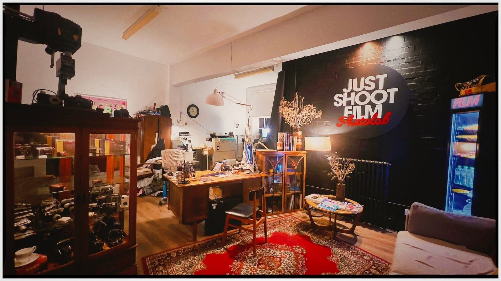 Inside Just Shoot Film Photolab in Norwich: the counter, the film fridge and the Just Shoot Film wall